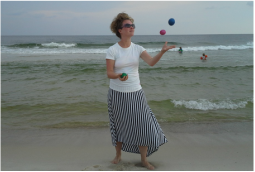 A photo of Kasey Hitt juggling on a beach.